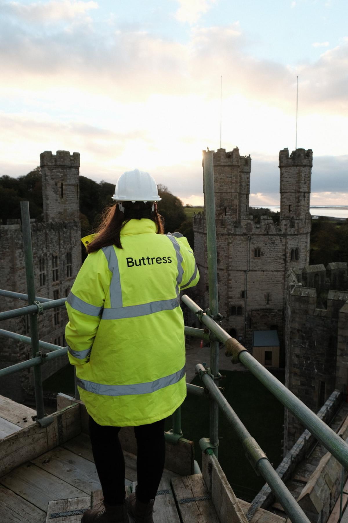buttress staff member in hi-vis looking out at castle work