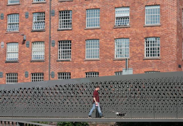 a man walks his dog in front of ancoats mills