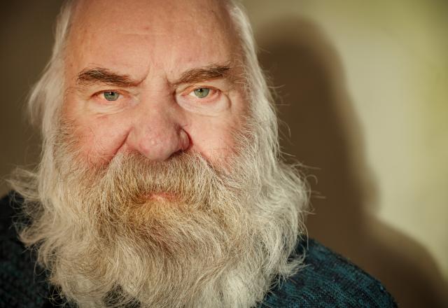 a close up of a man's face he las a long white beard and hair