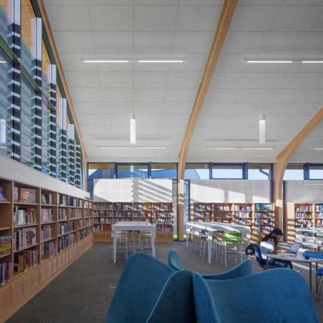 a modern school library with arched roof and timber beams