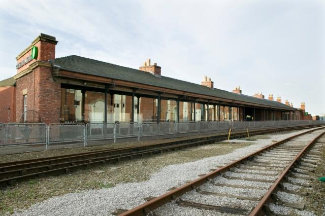 Exterior photo of a historic railway station and track