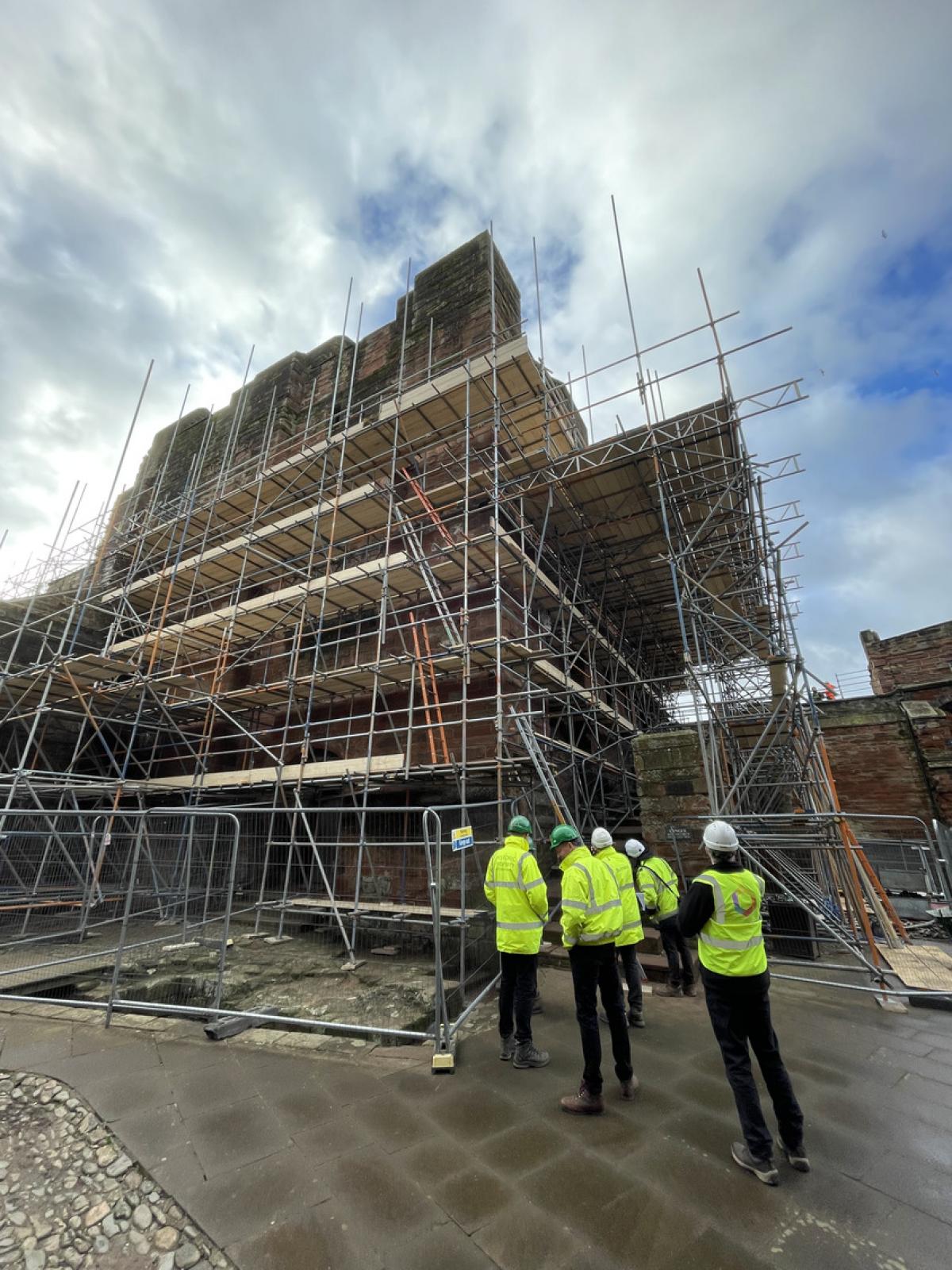 buttress staff in hi-vis admiring castle work