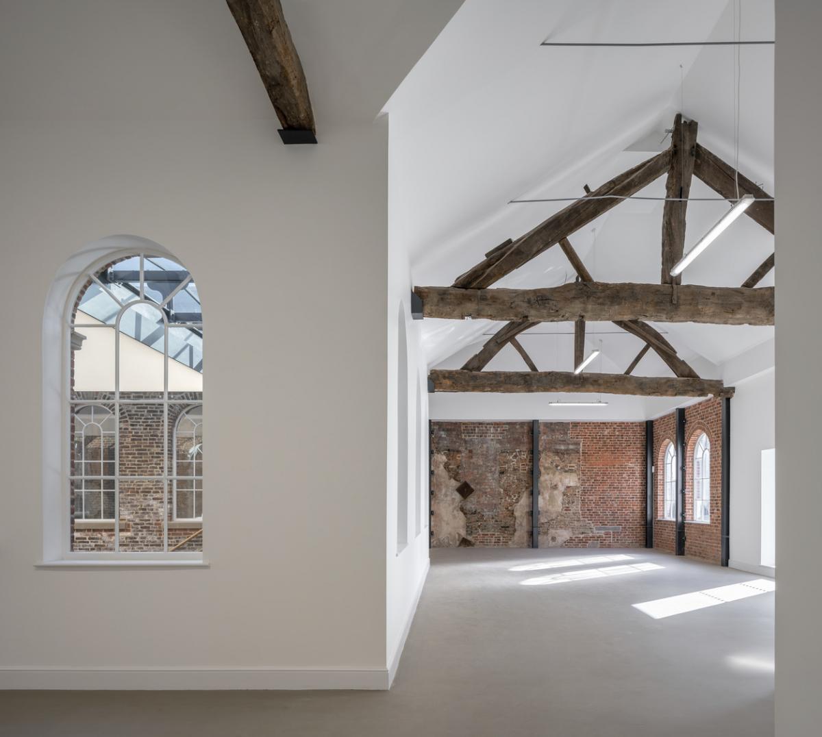 alternative interior of the first white cloth hall - white walls and wooden beams across ceiling