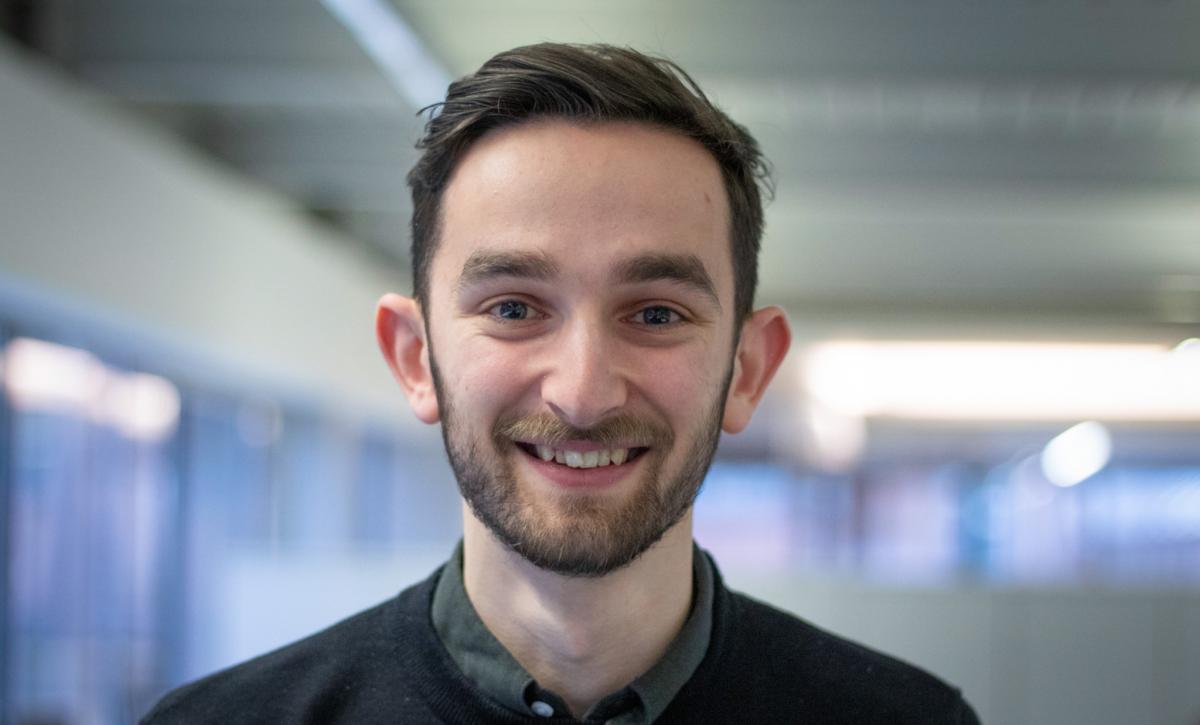 headshot of adam lewis, smiling