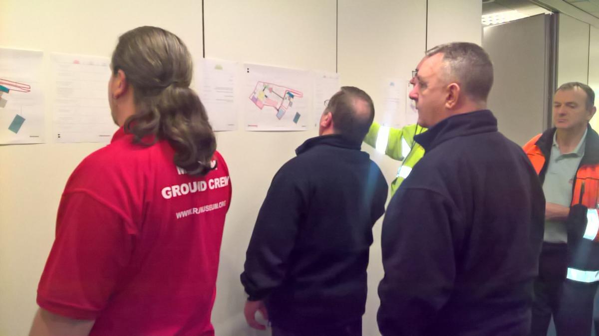 group of men participating in workshop activity on wall