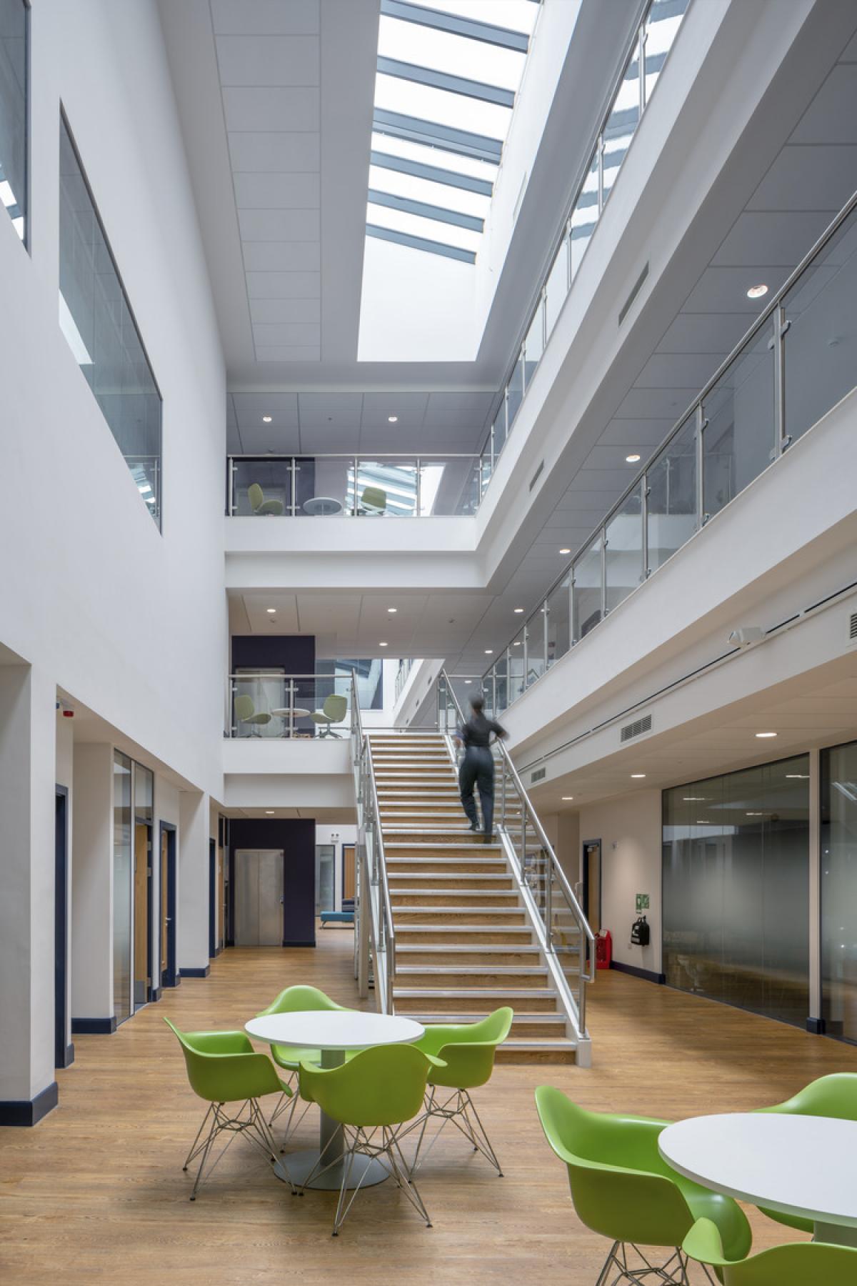 interior of eastern command and custody centre, high ceilings, and large foyer with green seats and white tables