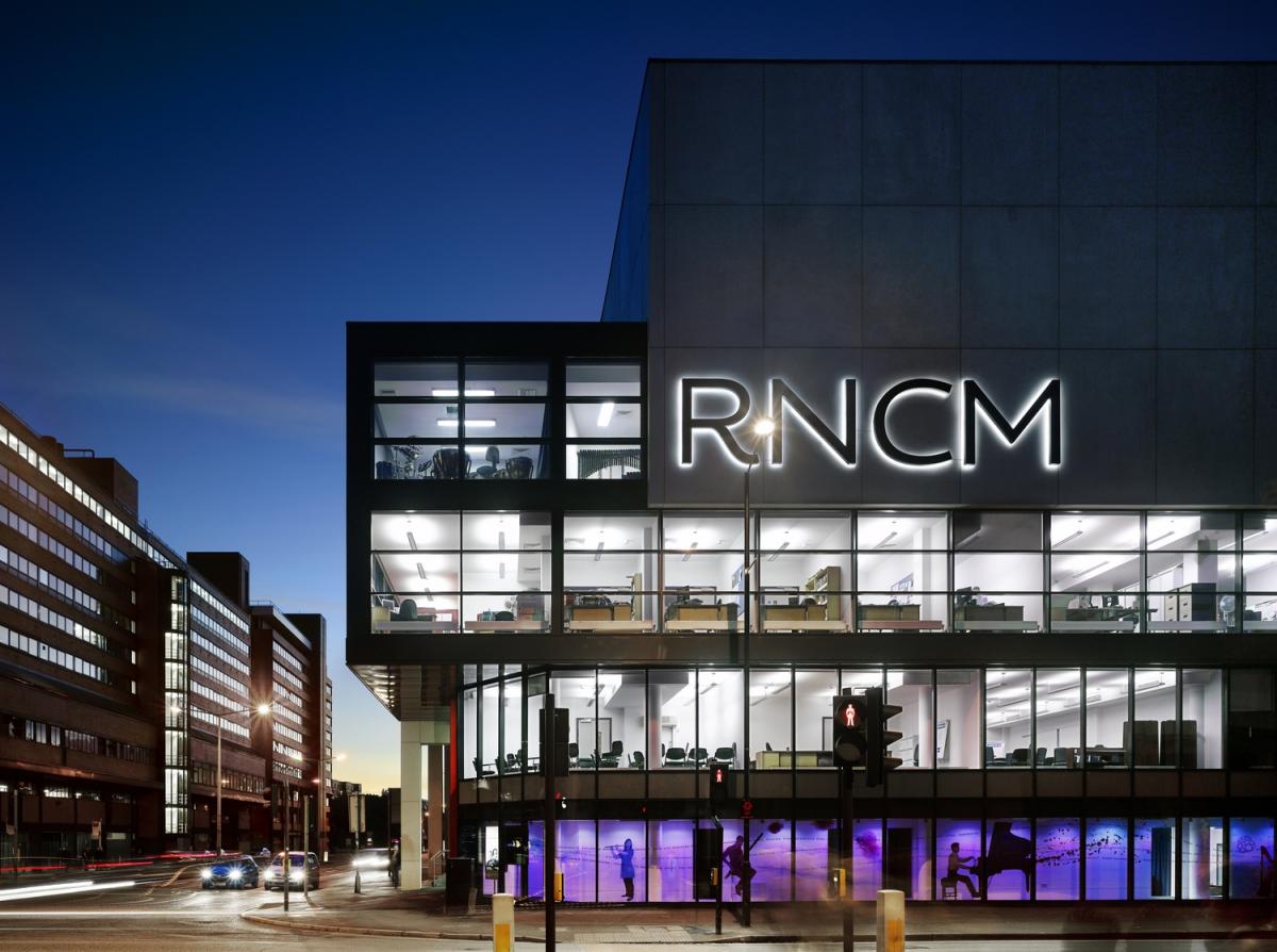 Exterior image of a contemporary conservatoire at night.