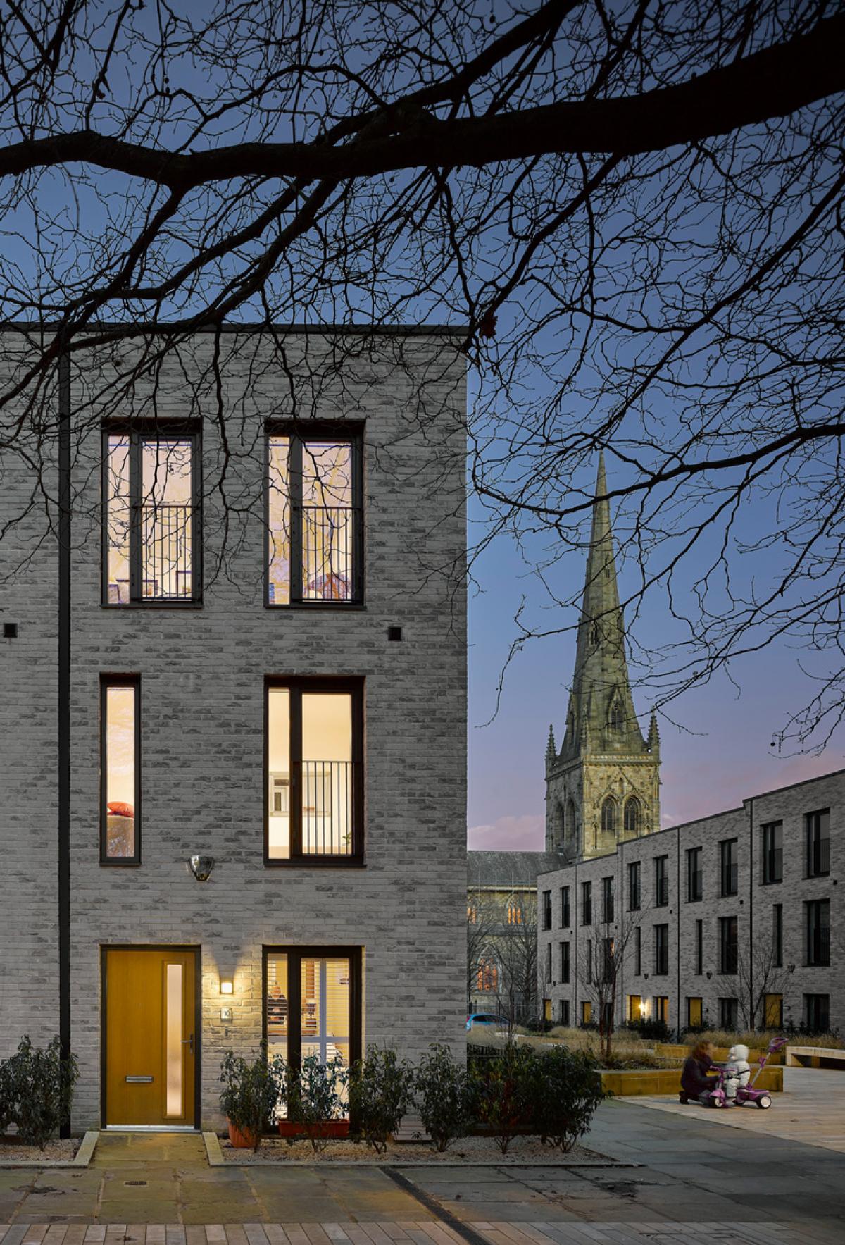 Exterior image of a modern townhouse at dusk.