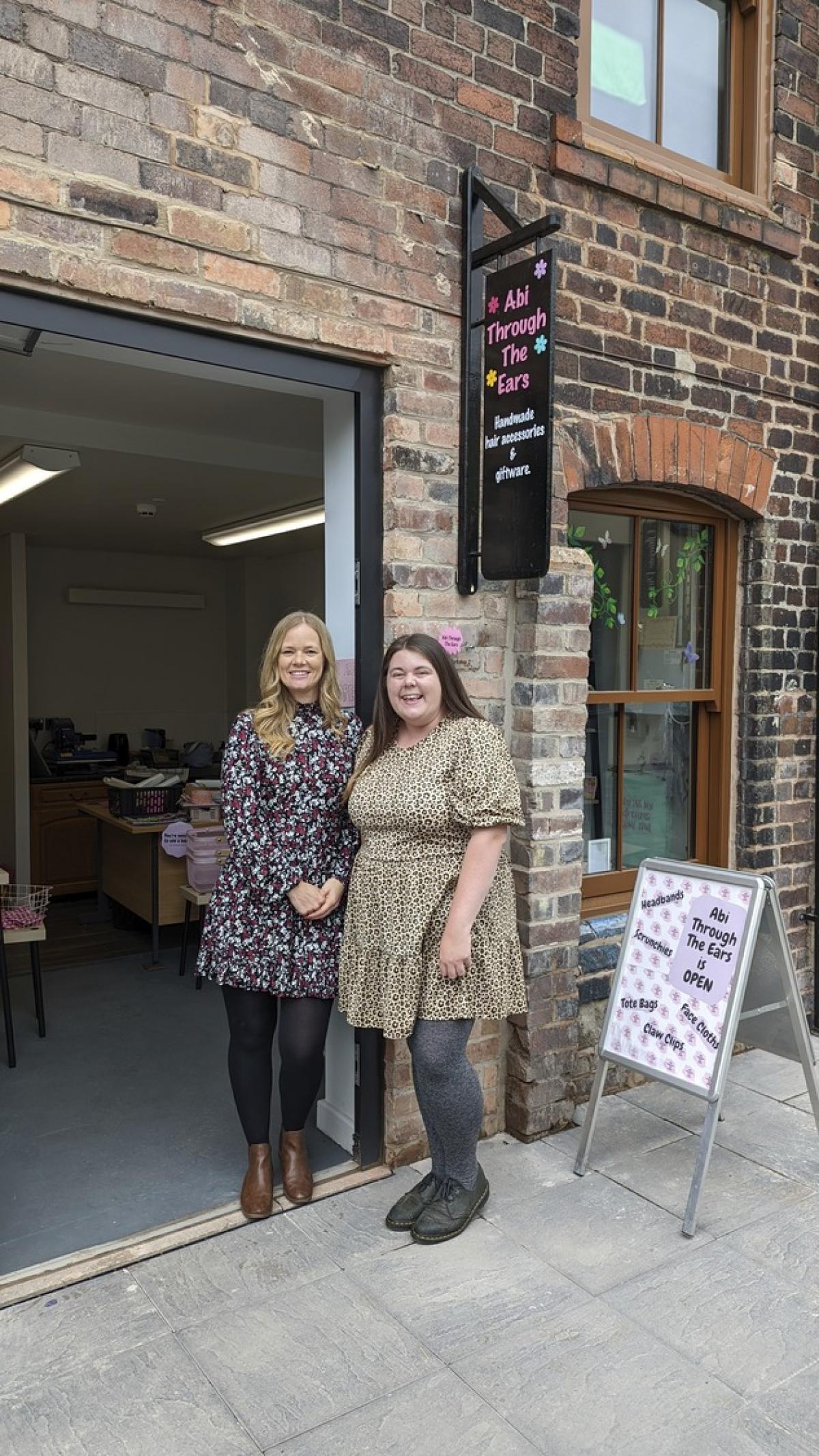 two women standing outside pottery posing