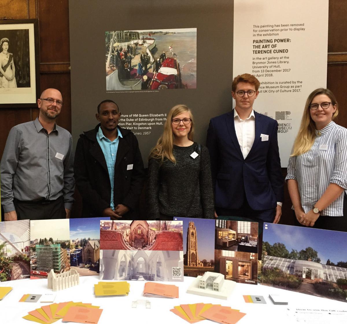 group of people posing for photo behind display at event