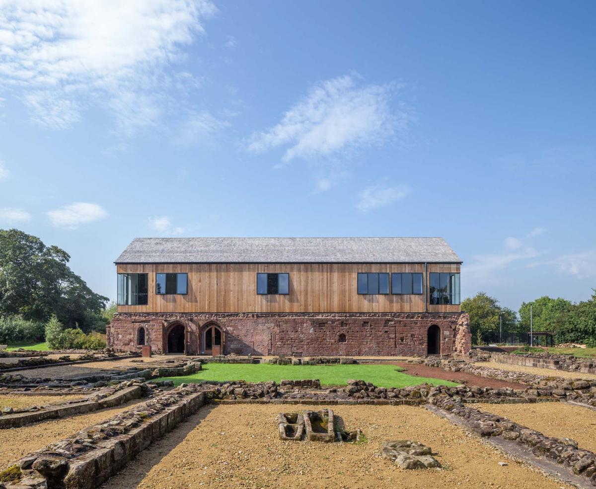 exterior of norton priory, large glass windowed foyer and wooden structure building on top of monastery