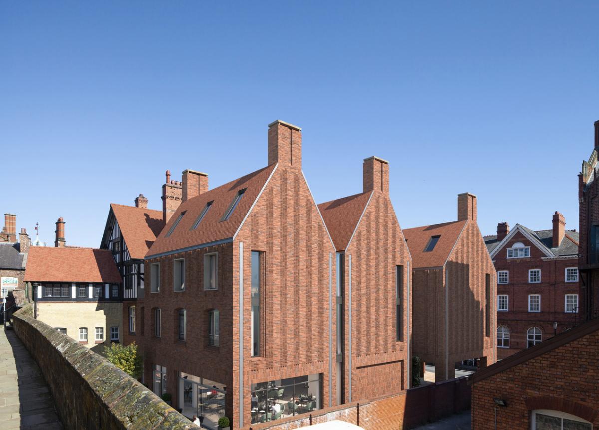 a brick building with three gables and vertical slot windows