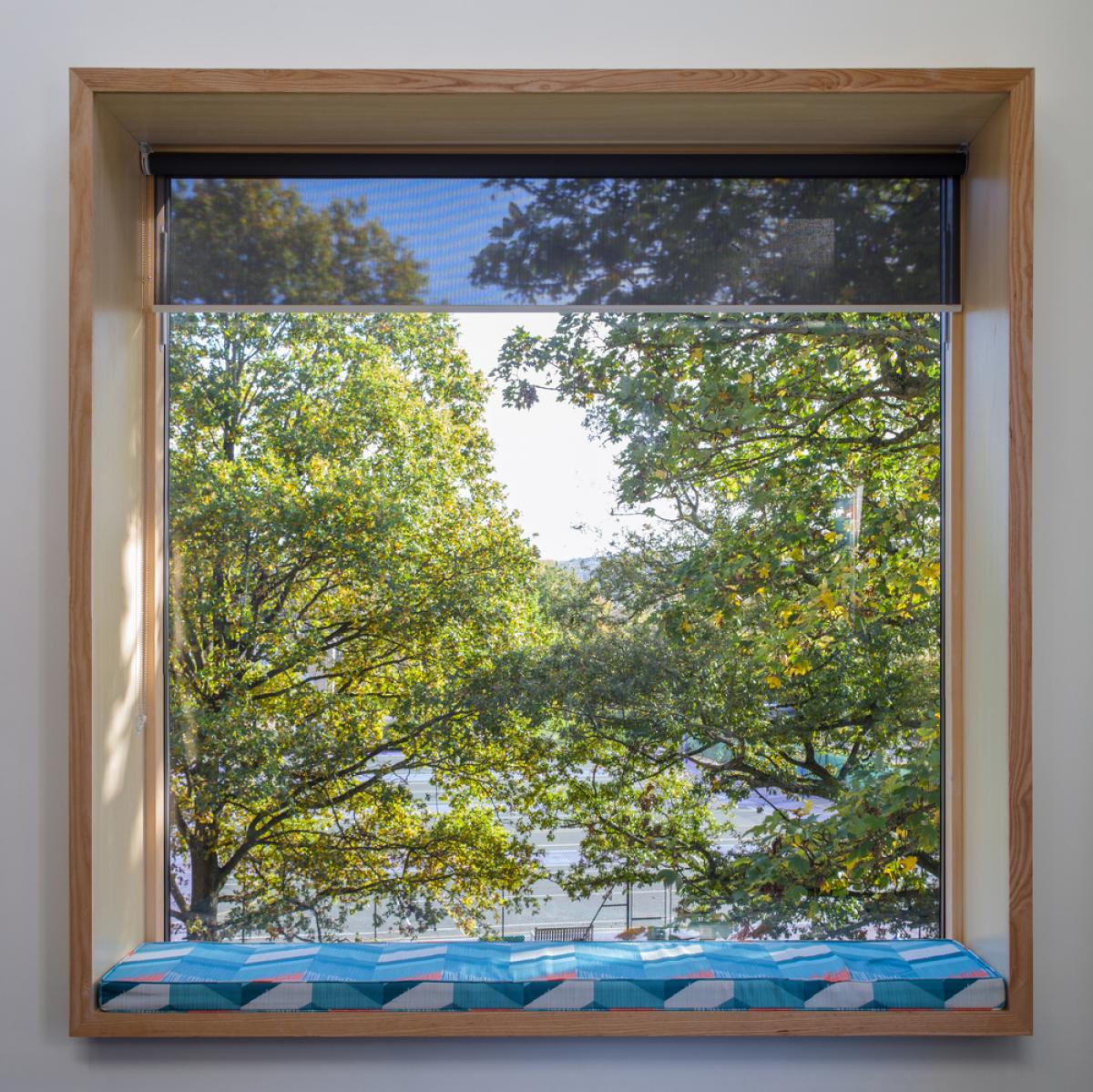 a square window with window seat and turquoise cushion