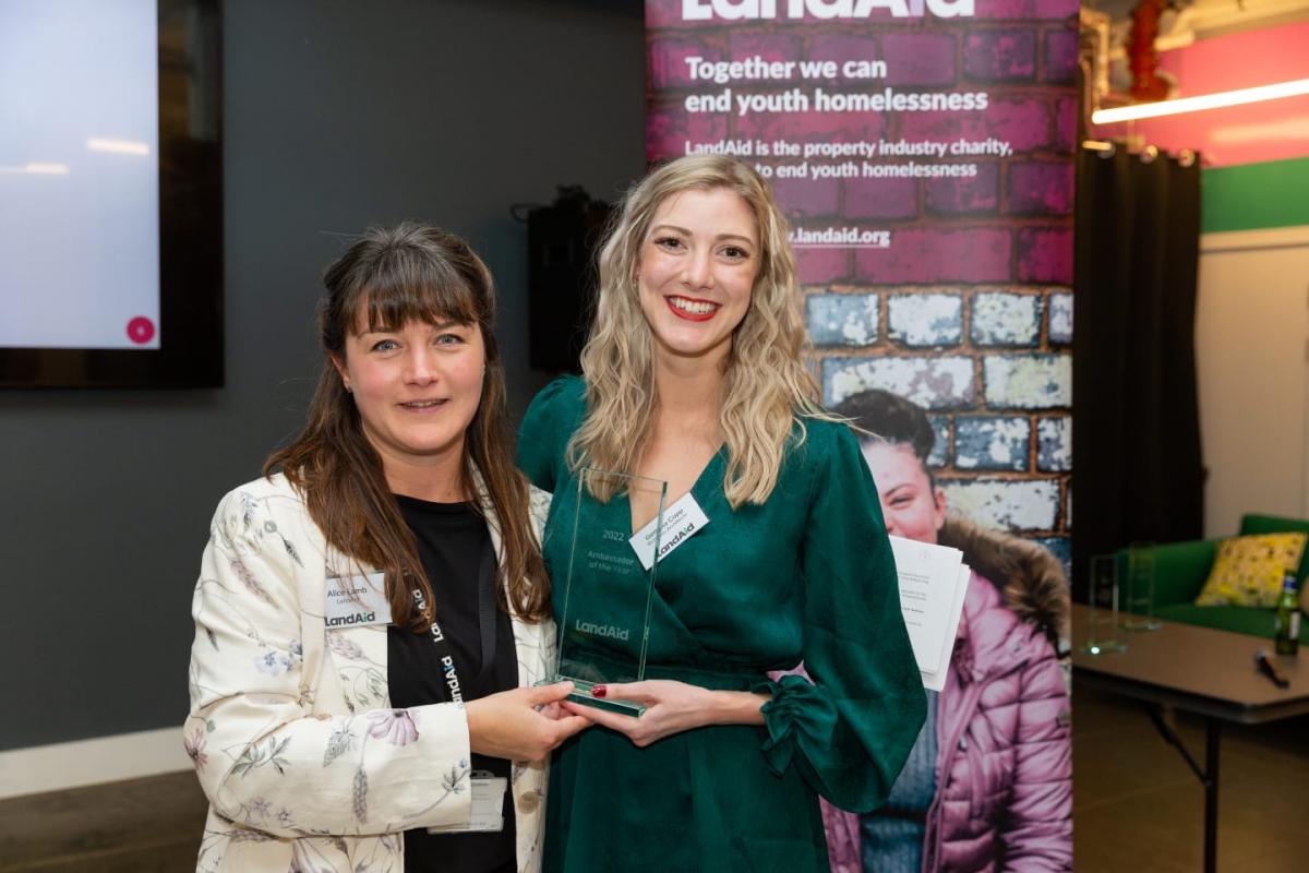 Two women at an awards ceremony holding an award.