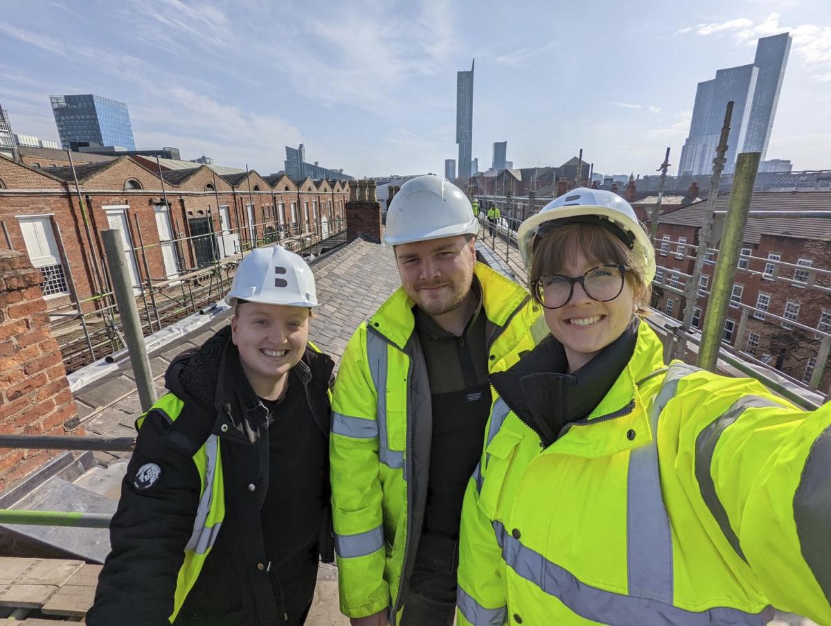 Image of three people smiling, wearing high-vis jackets and hard hats.
