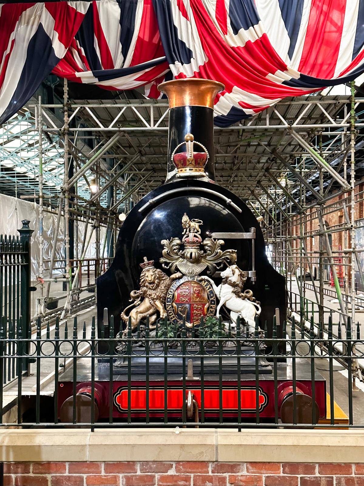 Victorian train with flags draped above it. 