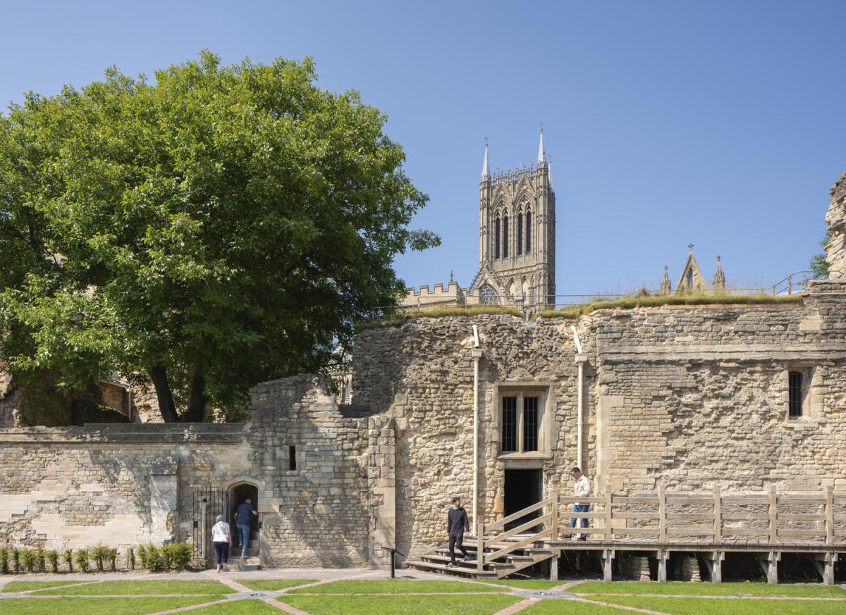 An old stone building with a tree on the left hand side