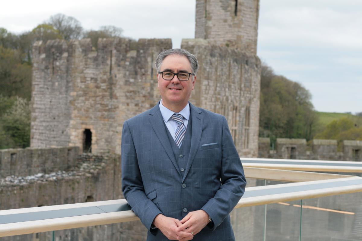Chris Wilson standing against railings at Caernarfon Castle