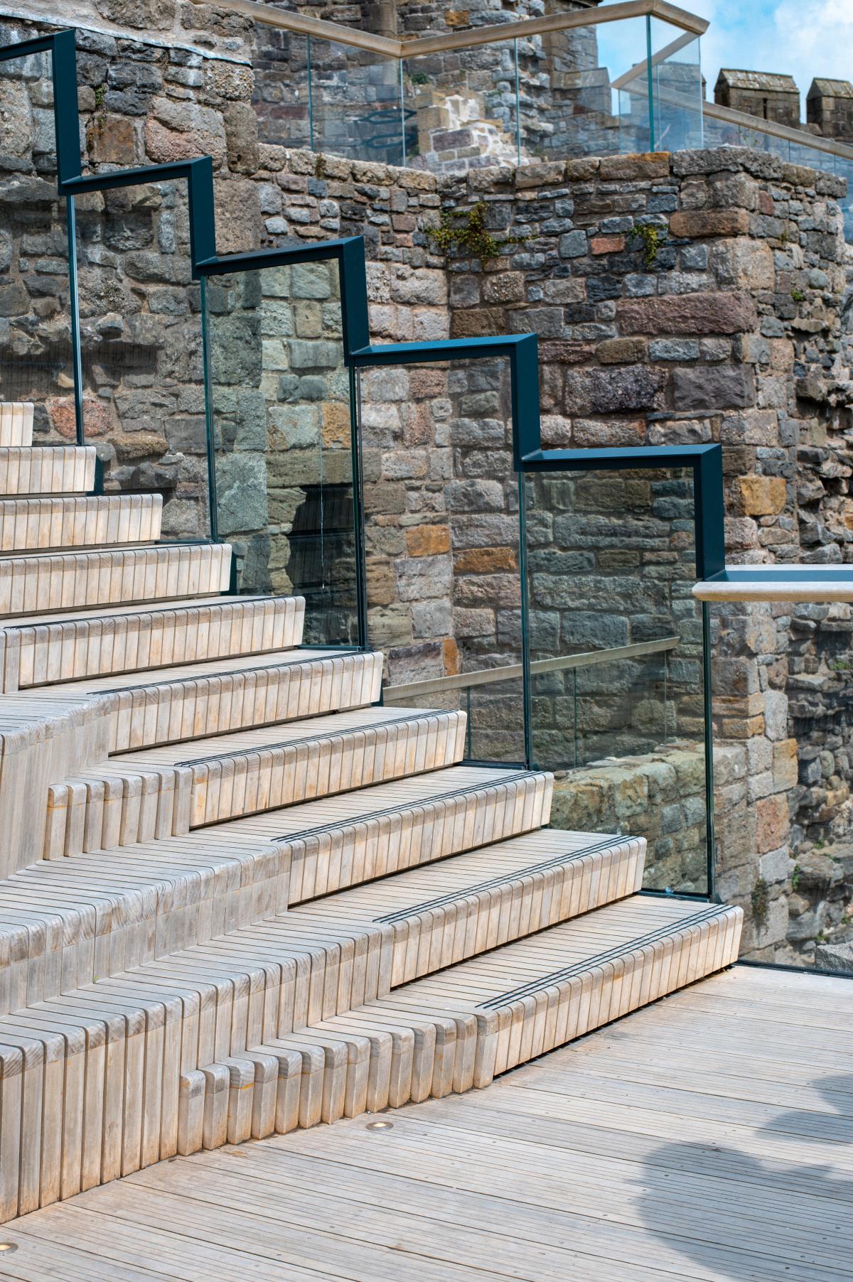 The timber steps at Caernarfon Castle with the glass balustrade and handrail.