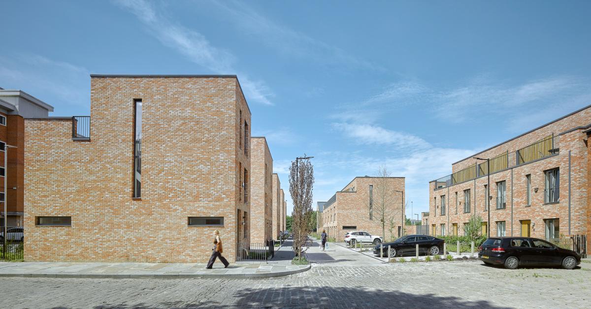 the gable of a contemporary townhouse frames the vista of Valette Square in Salford