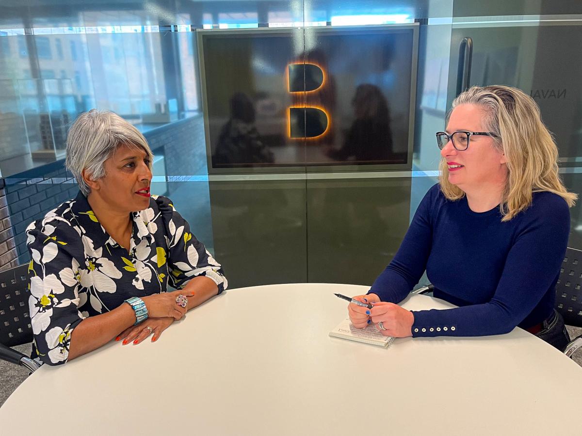 Two women sitting at a round table. 