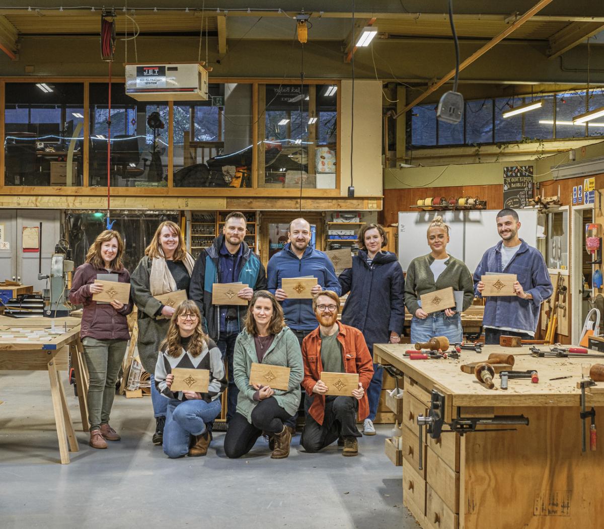 Group of people holding signs in a workshop after attending a workshopping event