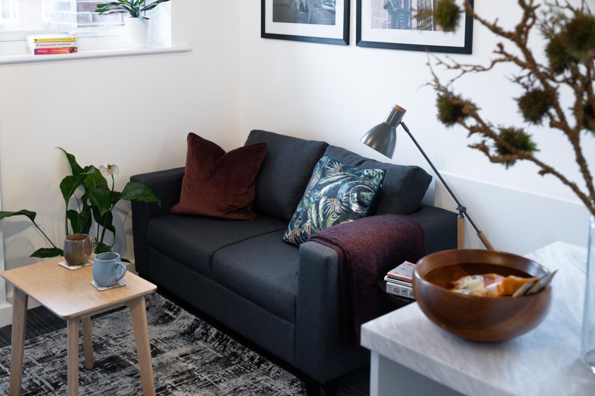 interior image - which shows a small two-seater settee, small coffee table, plants and pictures. 