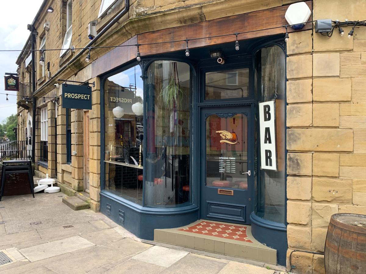 a navy blue historic shopfront in a stone building