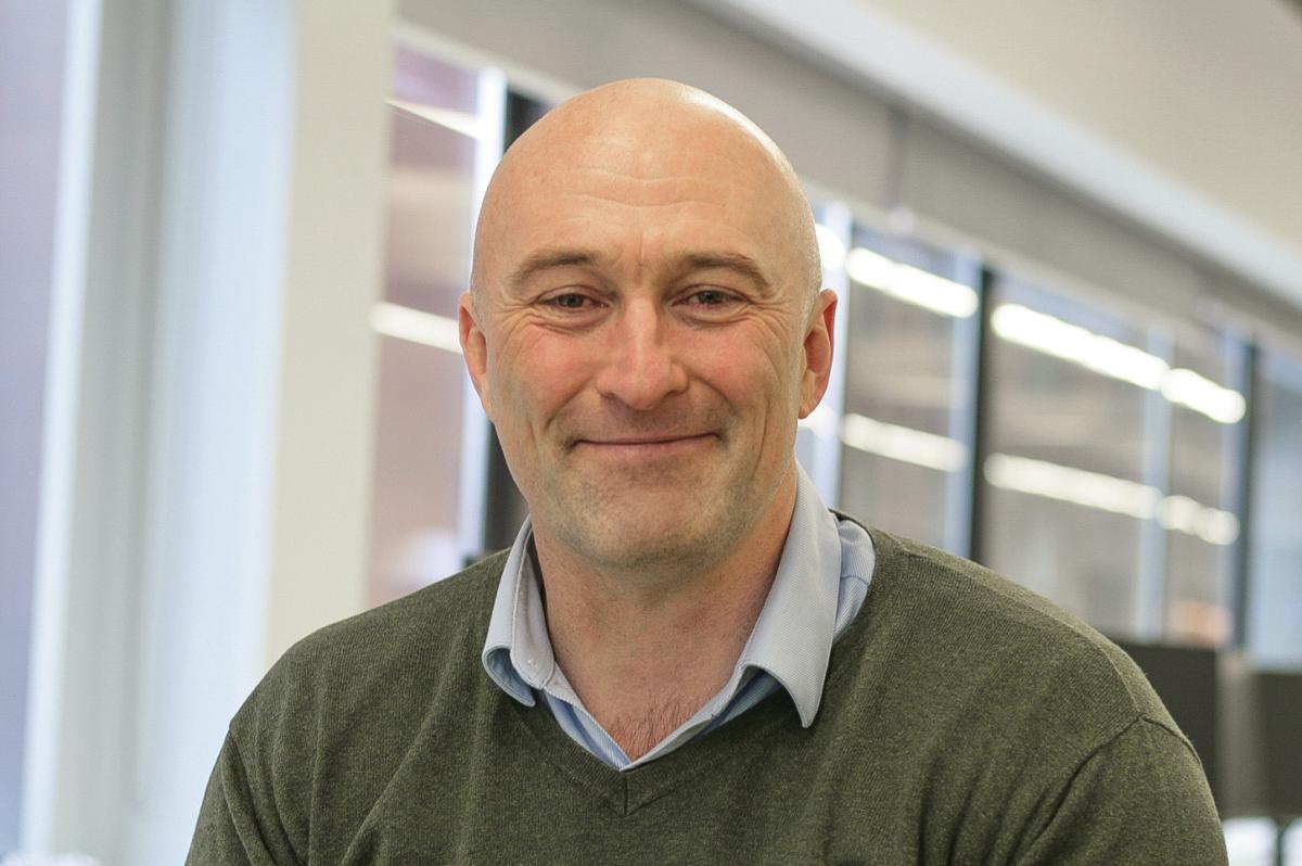 Headshot of David Parkinson, a man wearing a green jumper looking at the camera
