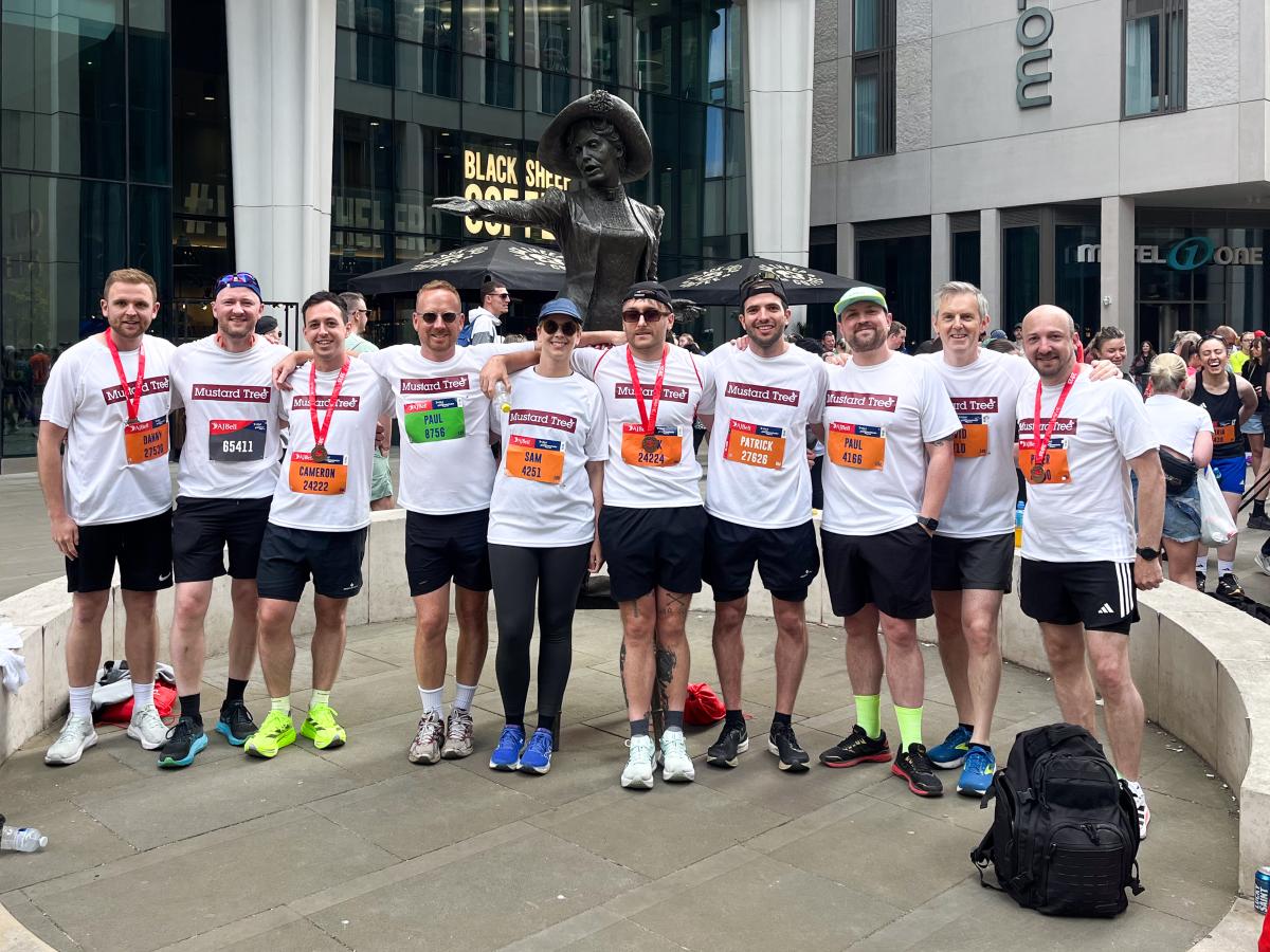 Group of Buttress employees, standing side by side wearing marathon medals