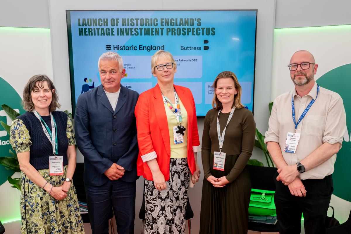 Five people stood next to each other in front of a presentation screen.