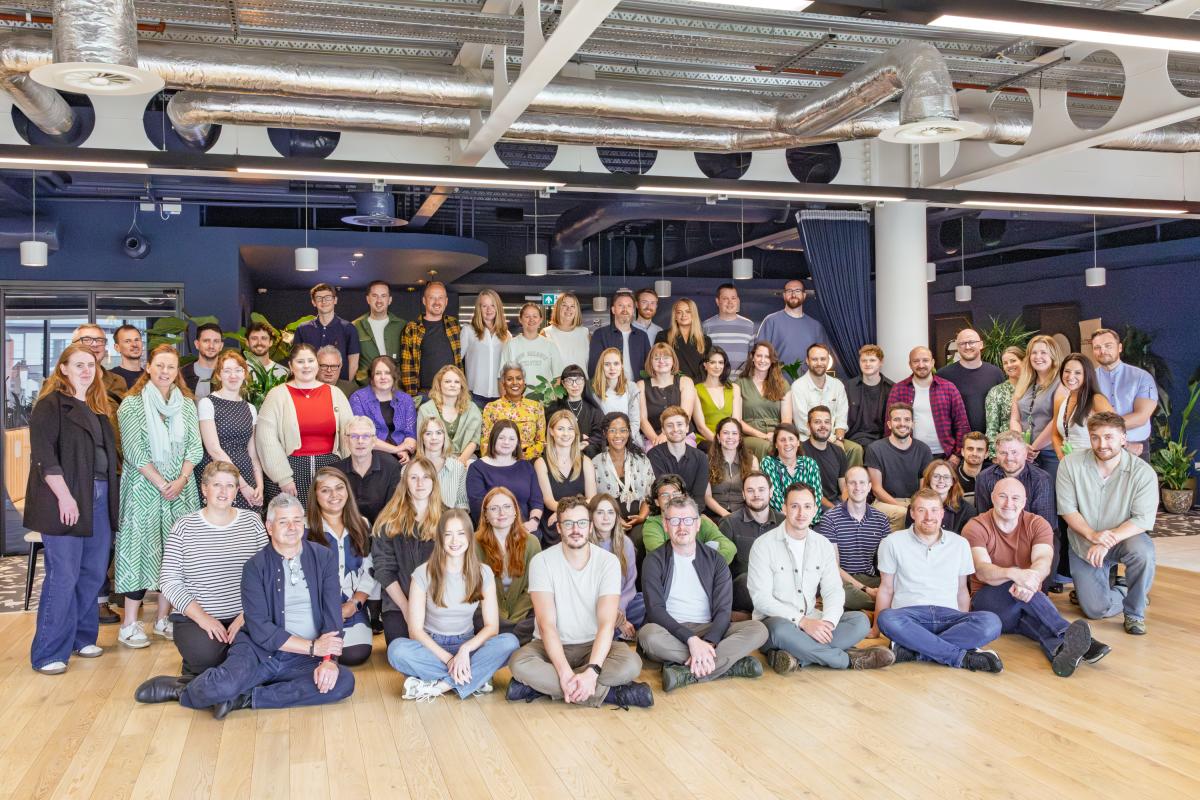 Group photo of 80 people sitting or standing and looking into the camera