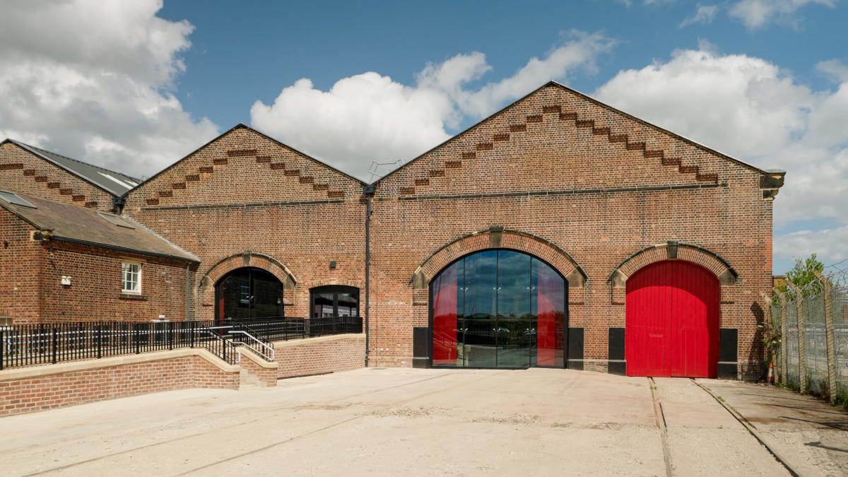 Exterior of Station Hall - a red brick building with a red door and a glazed windw