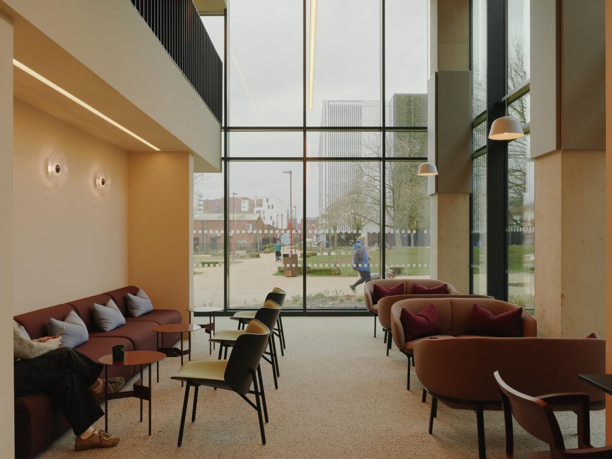 An interior view of a open seated social area, with a full glazed view to outside.