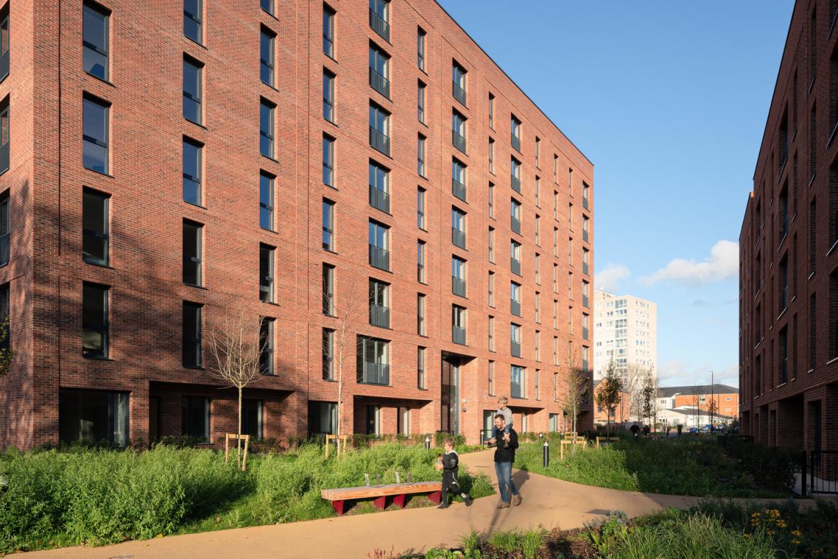 A red brick apartment block with green grounds