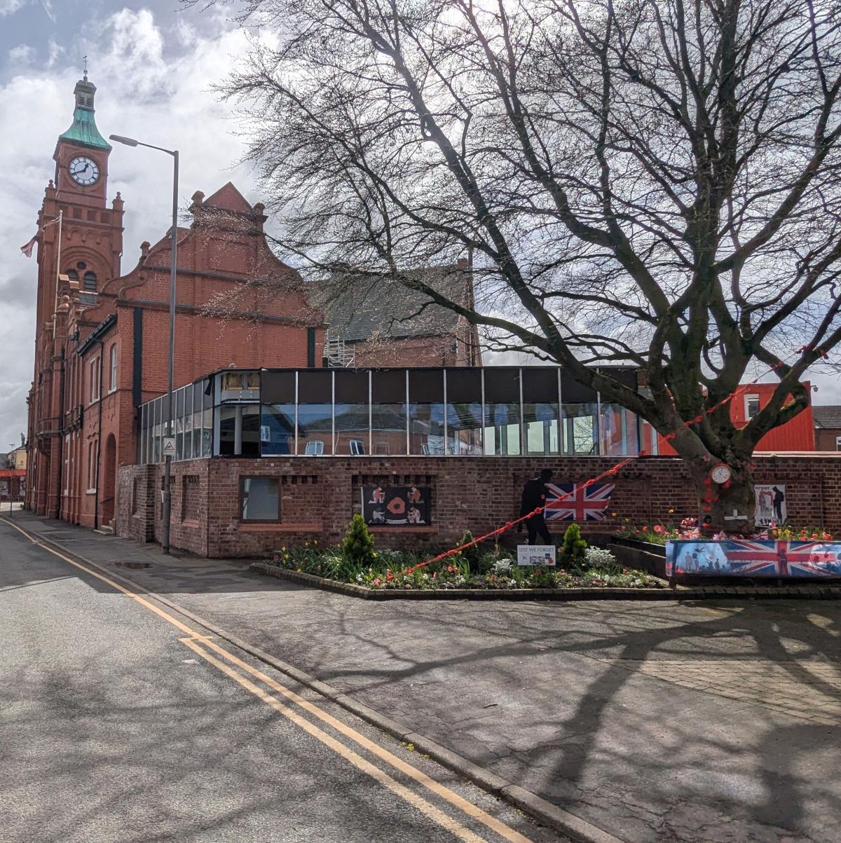 External shot of the red brick town hall building with an adjoining building with glazing.