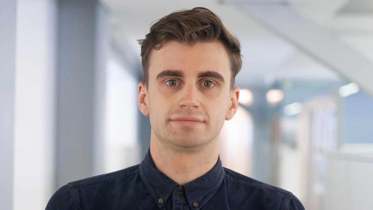 A young man wearing a dark shirt, with brown hair.