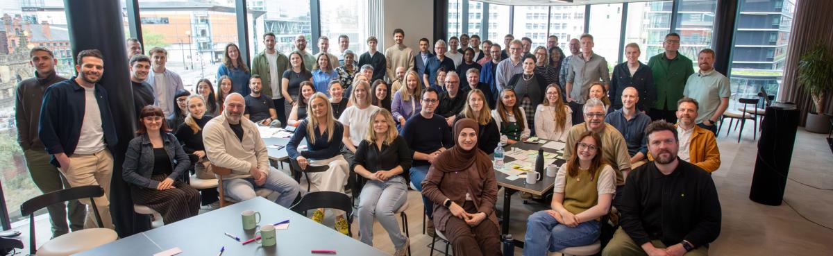 A large group of people gathered together in a meeting room.