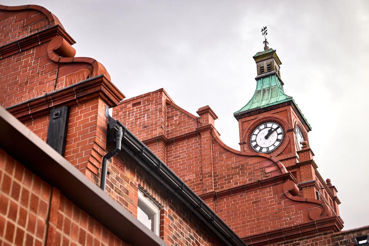 A clock tower on a red brick heritage building