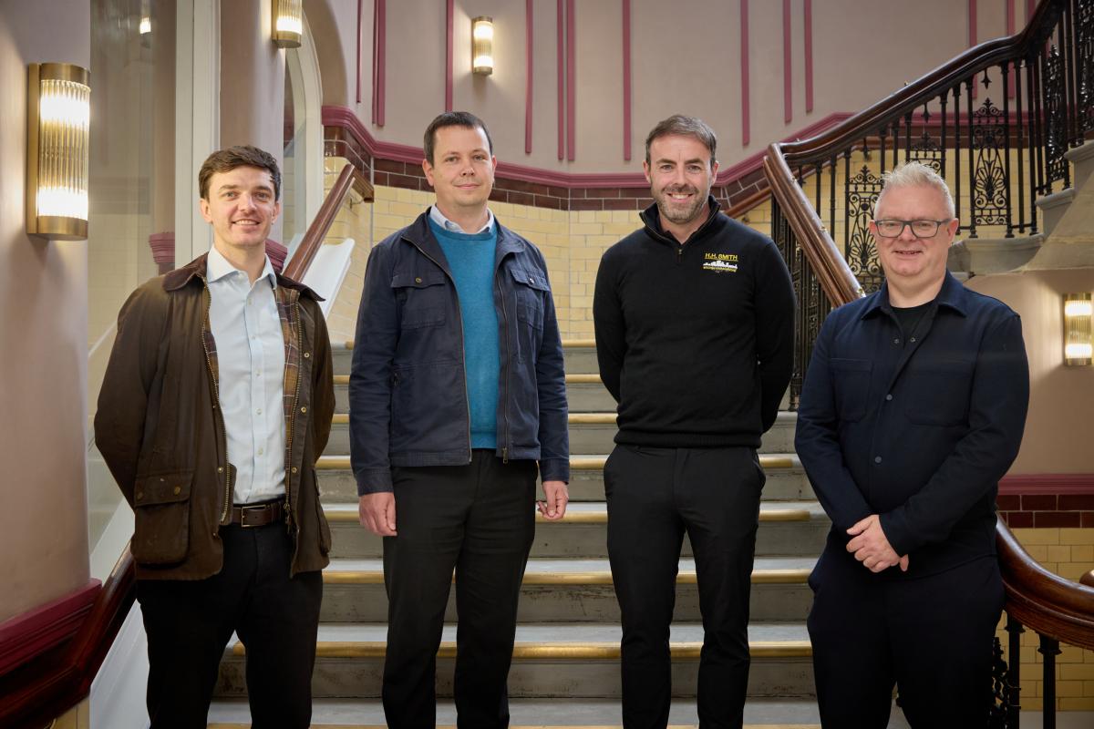 A group of men stood at the bottom of an internal staircase