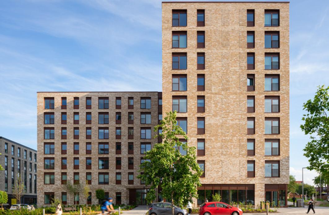 an apartment building in buff brick on a sunny day