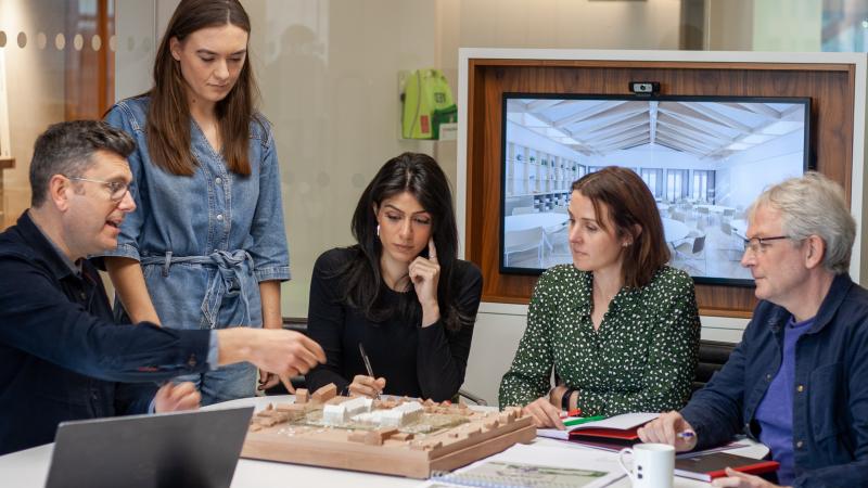 Group of architects examining a model.