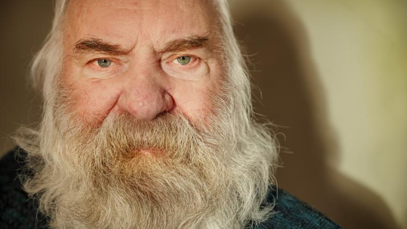 a close up of a man's face he las a long white beard and hair