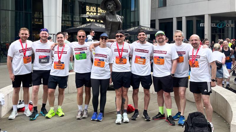 Group of Buttress employees, standing side by side wearing marathon medals