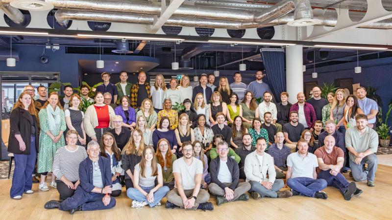 Group photo of 80 people sitting or standing and looking into the camera