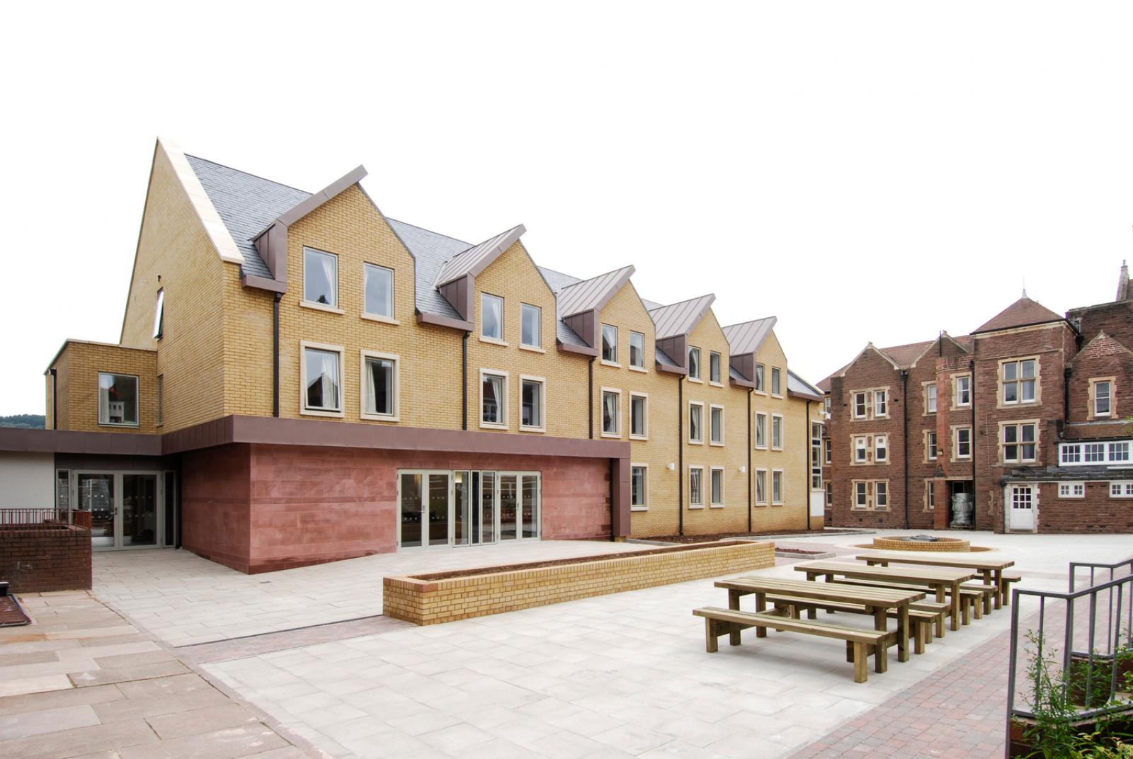 Exterior image of a contemporary sixth form boarding house, which opens onto a central courtyard.