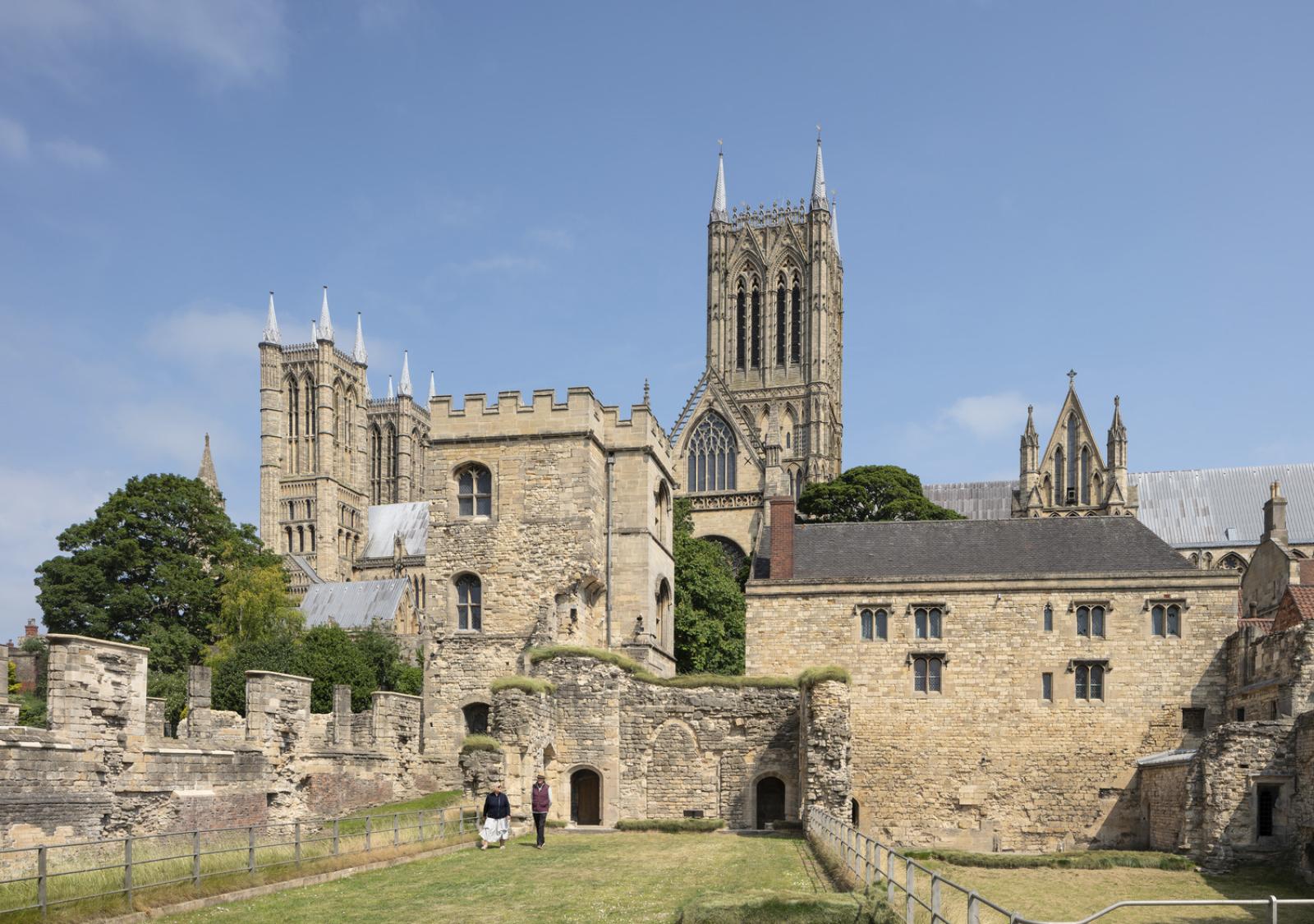 a stone ruin (Lincoln Medieval Bishops Palace) with a tower and a green lawn