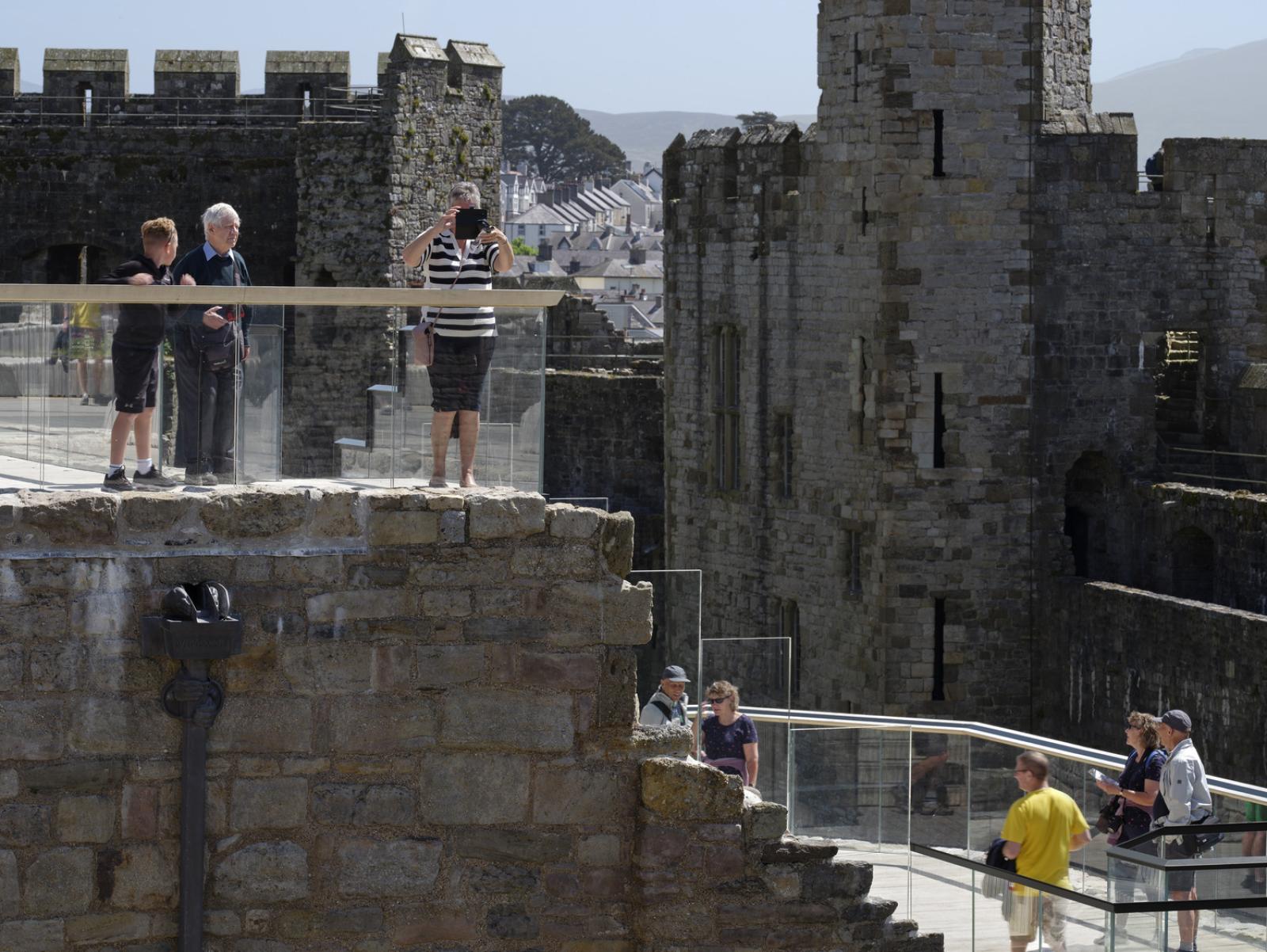 visitors mill about on two level external decks at caernarfon castle