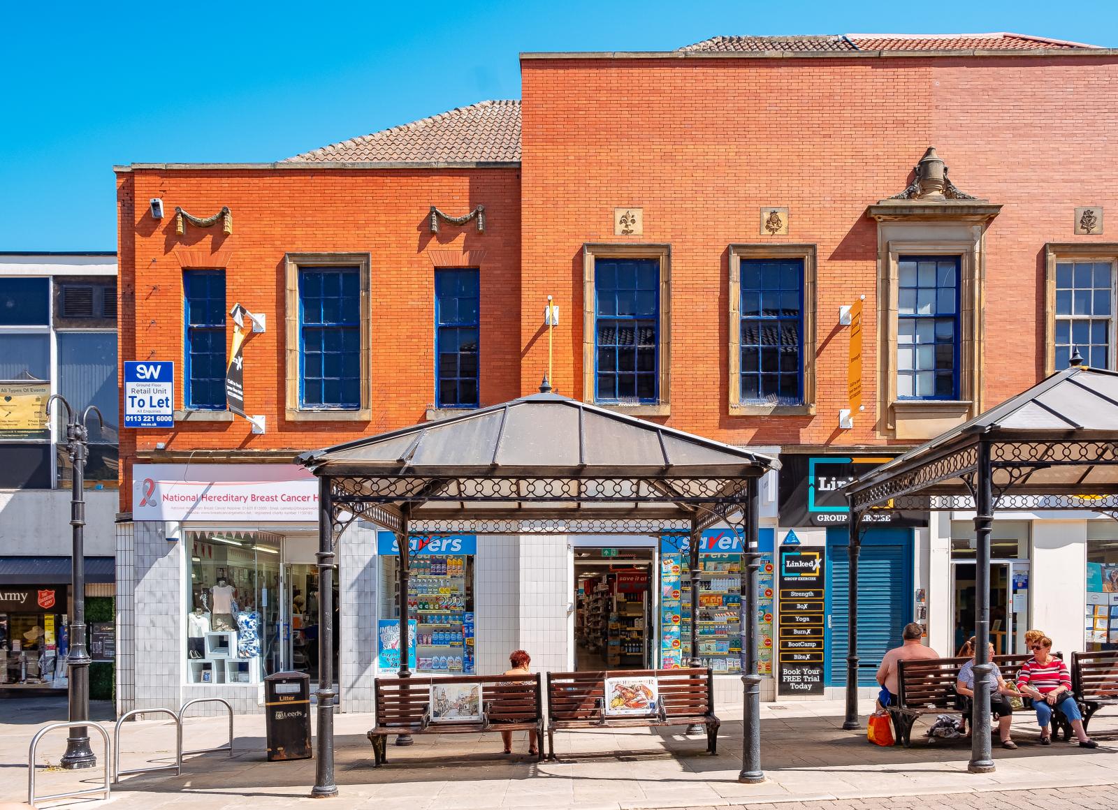 A red brick building in Morley with benches in front of it