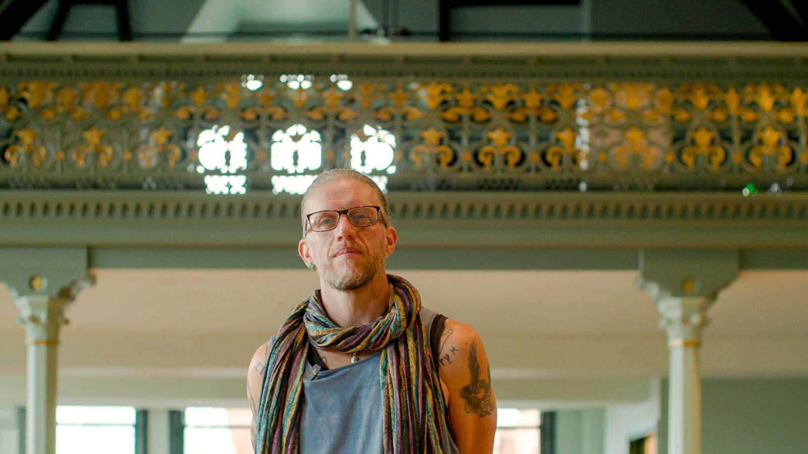 A man standing in front of a green balcony.